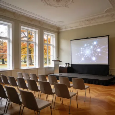 Tagungssaal in einem Schlosshotel im Herbst: hohe Fenster zum Park, Stuhlreihen vor einer kleinen Bühne mit Leinwand, auf der ein Netz aus verbundenen Punkten leuchtet