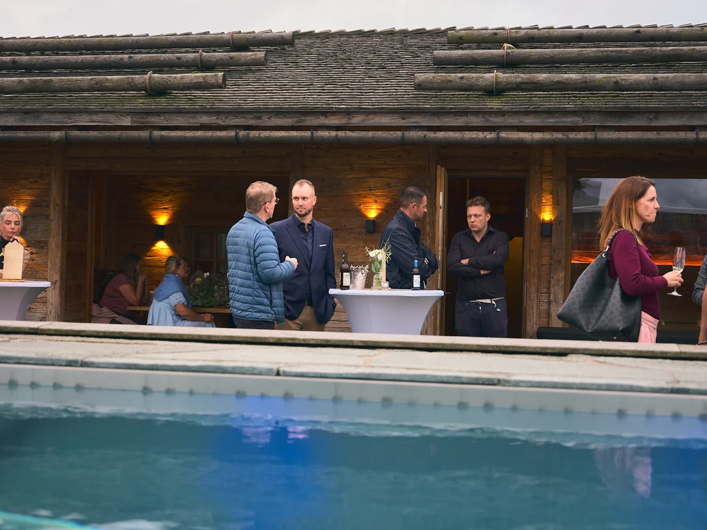 Gäste vor der Hütte auf der Dachterrasse, im Vordergrund der Pool