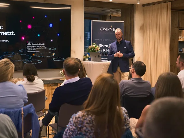 Michael Selck auf der Bühne beim ersten Abend „Betriebsgeheimnis KI“ im September 2026, auf der Leinwand das Wissensnetz des Firmengehirns