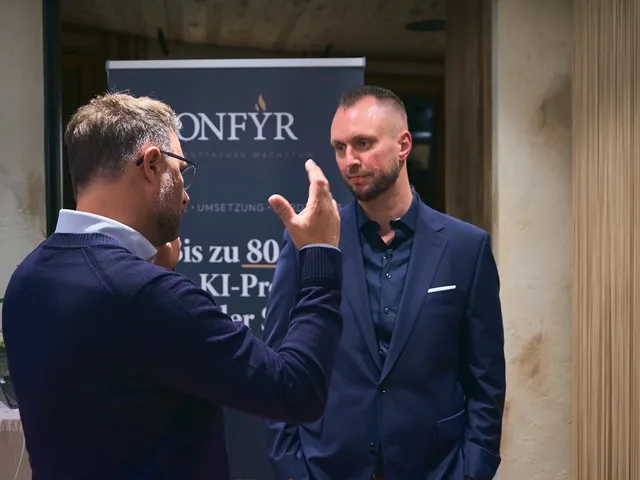 Michael Selck im Gespräch mit einem Gast vor dem ONFYR-Banner