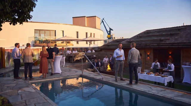 Dachterrasse des Chalet O in Rostock mit Pool und Gästen in der Abendsonne – Veranstaltung „Betriebsgeheimnis KI“