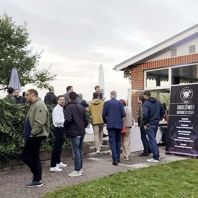 Auftakttreffen vor dem Vereinshaus im See-Idyll Schwerin — Gäste im Gespräch, am Eingang der Aufsteller des Baulöwen Business Club