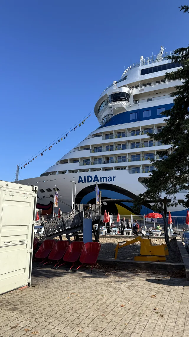 Der Bug der AIDAmar am Passagierkai in Warnemünde unter blauem Himmel